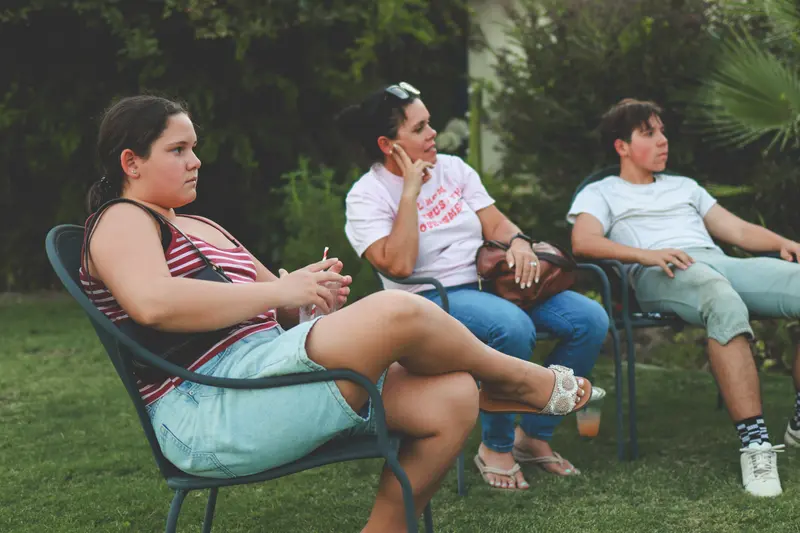 A family seated on the lawn at a community meet-and-greet