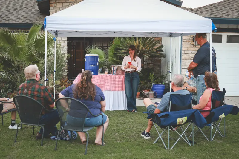 Residents gathered under a canopy for a neighborhood meet-and-greet